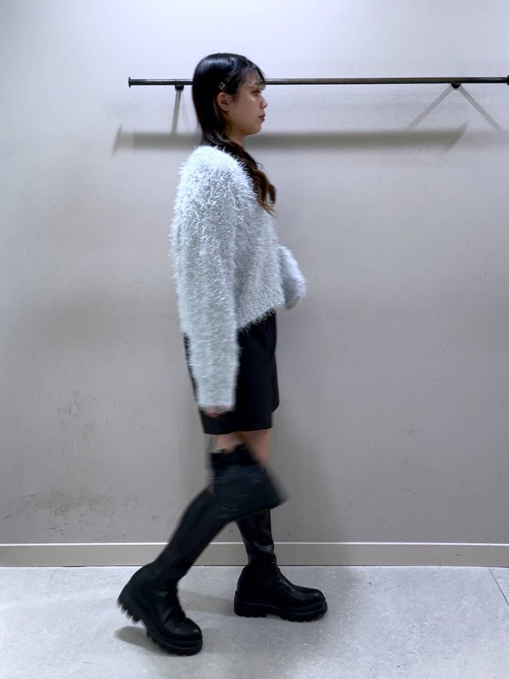 ブラック系のニット/セーター、ブラック系のブーツ、ブラック系のショルダーバッグを着用したレディースの冬コーディネートの4枚目の写真