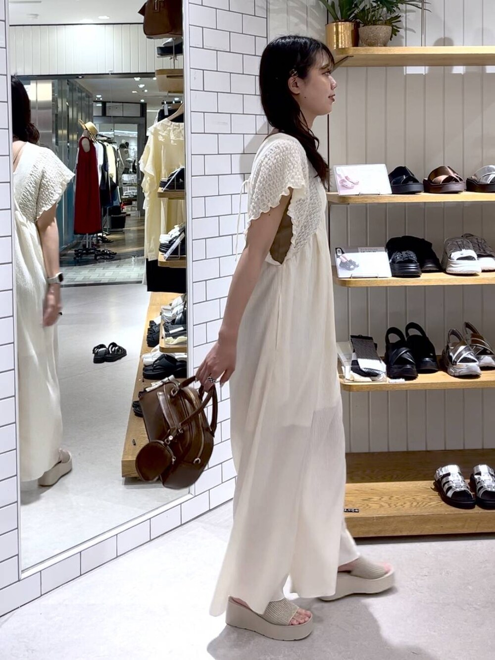 ベージュ系のTシャツ/カットソー、ホワイト系のサンダル、ホワイト系のサロペット/オーバーオールを着用したレディースの夏コーディネートの4枚目の写真