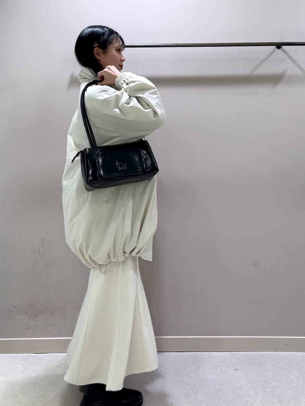 ホワイト系のその他アウター、ブラック系のブーツ、ホワイト系のスカートを着用したレディースの冬コーディネートの5枚目の写真