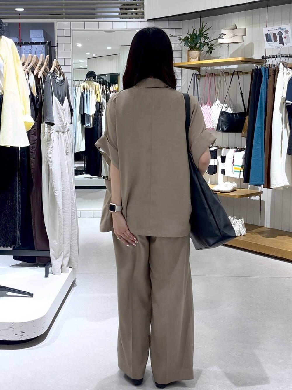 ブラック系のショルダーバッグ、ブラック系のスニーカー、ホワイト系のTシャツ/カットソーを着用したレディースの夏コーディネートの3枚目の写真