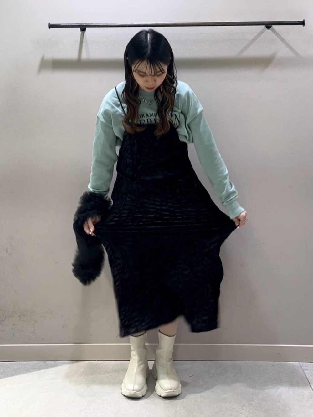 ホワイト系のブーツ、グリーン系のスウェット、ブラック系のワンピースを着用したレディースの冬コーディネートの6枚目の写真