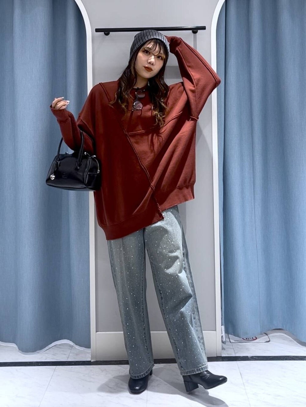 ブルー系のデニムパンツ、ブラック系のブーツ、ブラック系のボストンバッグを着用したレディースの冬コーディネートの7枚目の写真