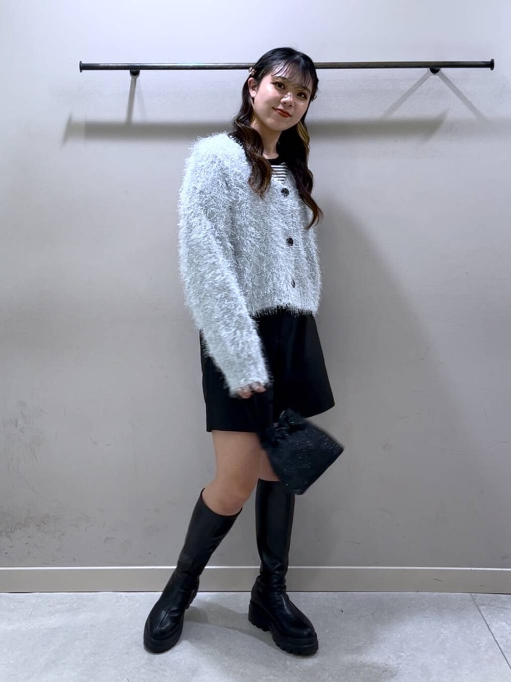 ブラック系のニット/セーター、ブラック系のブーツ、ブラック系のショルダーバッグを着用したレディースの冬コーディネートの5枚目の写真