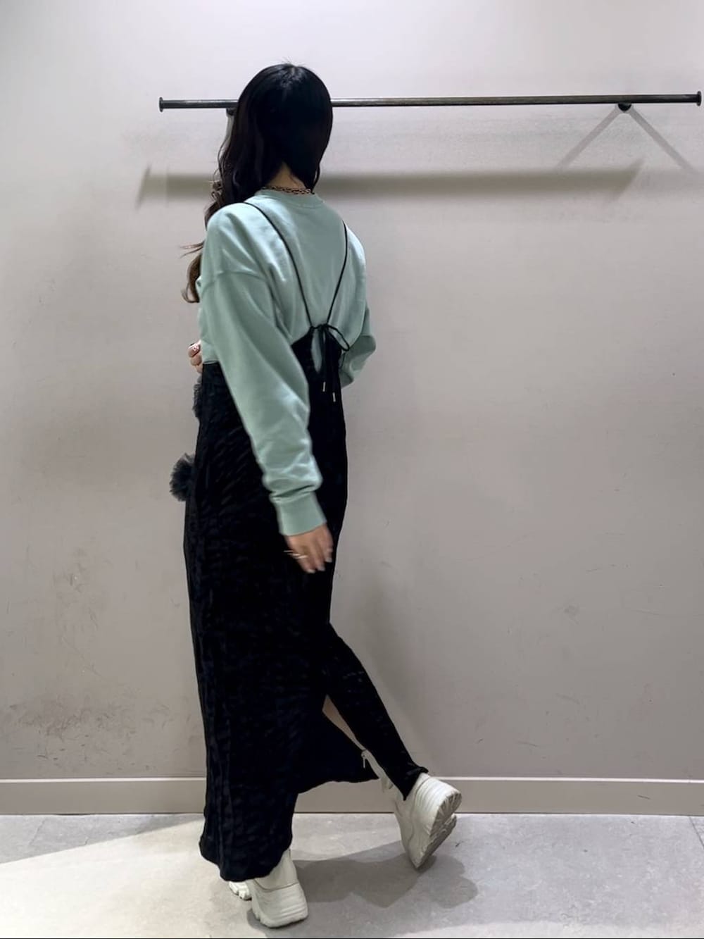 ホワイト系のブーツ、グリーン系のスウェット、ブラック系のワンピースを着用したレディースの冬コーディネートの3枚目の写真