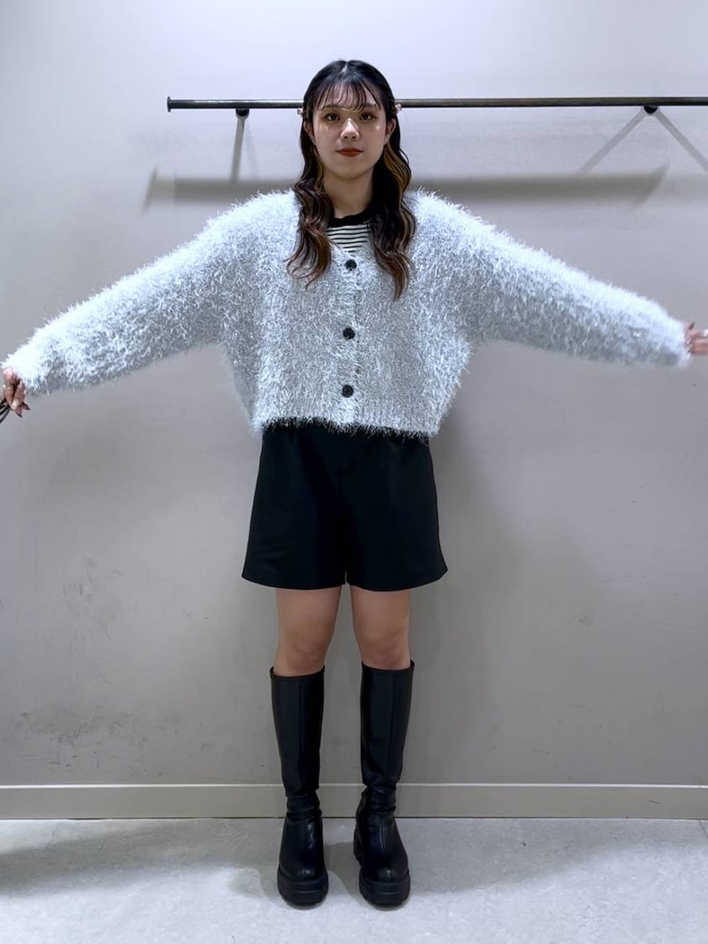 ブラック系のニット/セーター、ブラック系のブーツ、ブラック系のショルダーバッグを着用したレディースの冬コーディネートの7枚目の写真