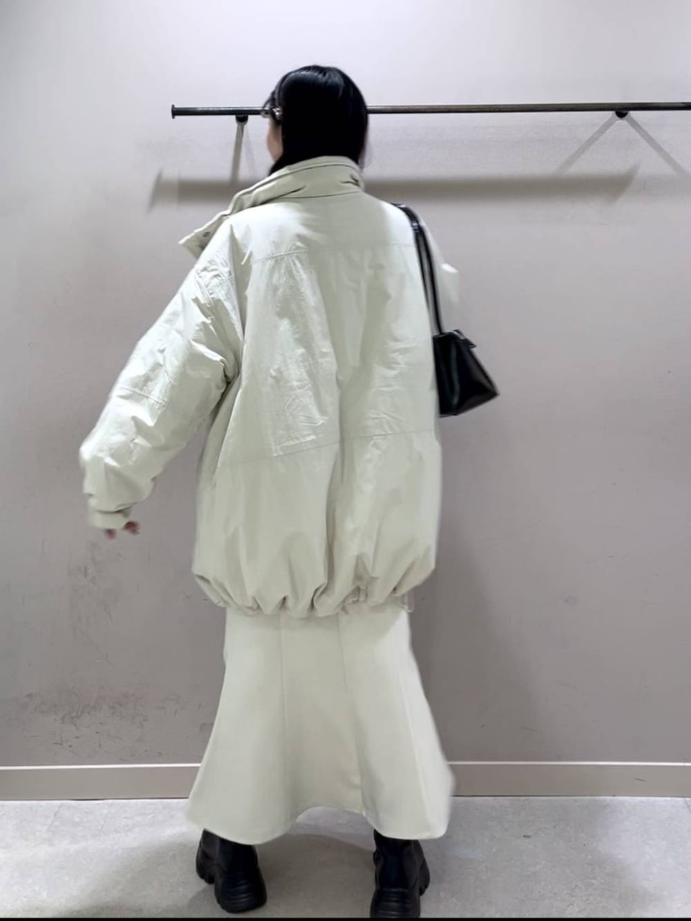 ホワイト系のその他アウター、ブラック系のブーツ、ホワイト系のスカートを着用したレディースの冬コーディネートの3枚目の写真