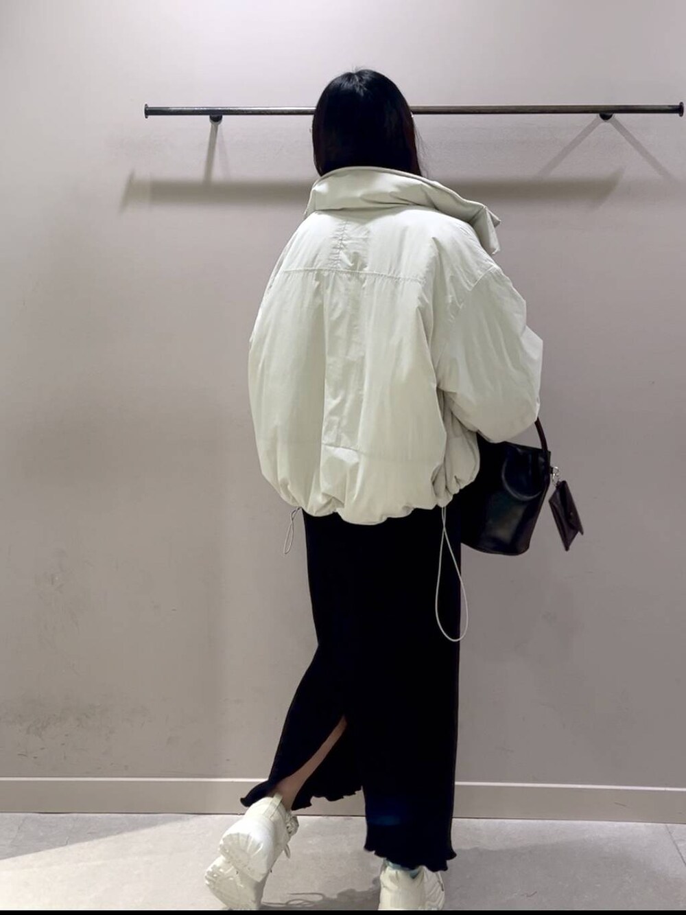 レッド系のニット/セーター、ホワイト系のその他アウター、ブラック系のスカートを着用したレディースの冬コーディネートの4枚目の写真