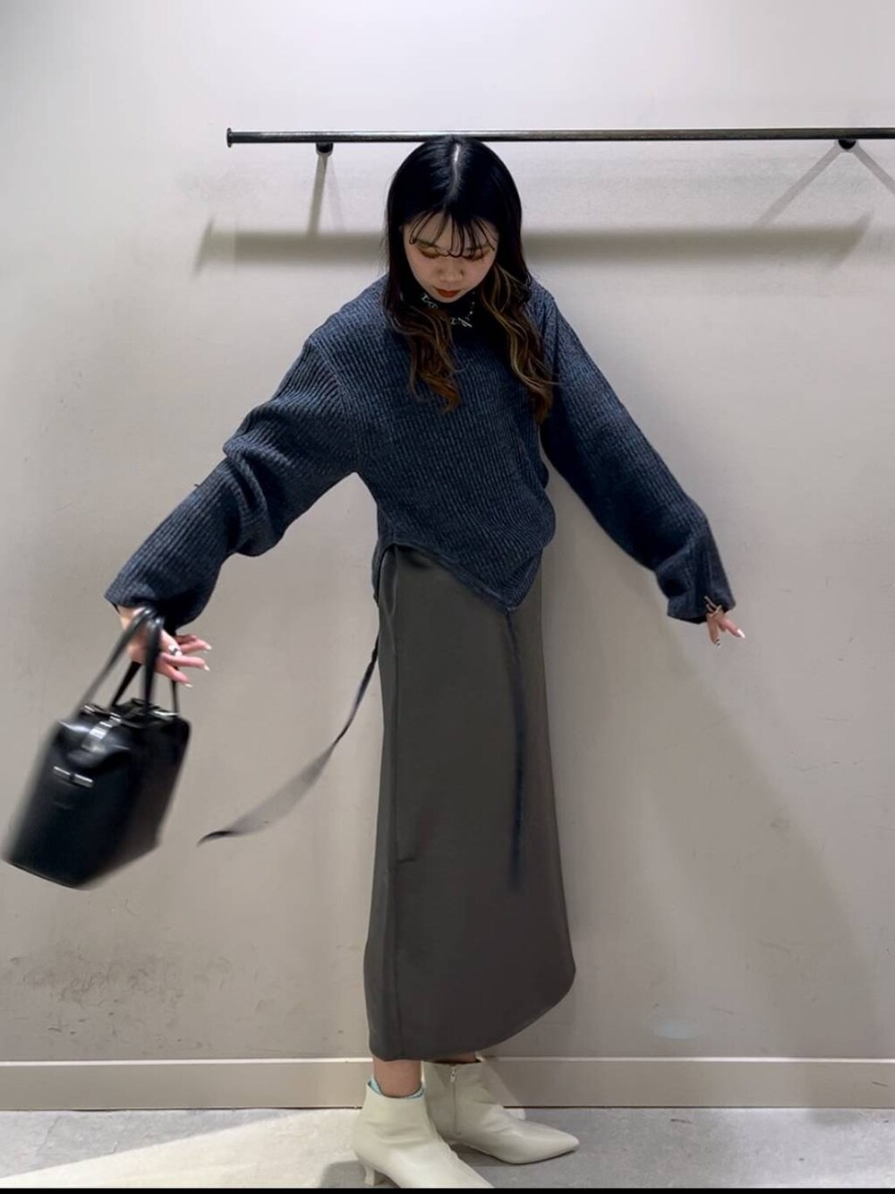 ブルー系のワンピース、ブラック系のショルダーバッグ、ホワイト系のブーツを着用したレディースの冬コーディネートの5枚目の写真