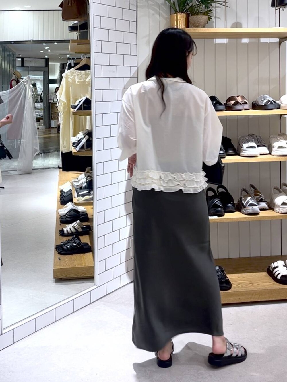 ベージュ系のTシャツ/カットソー、グレー系のスカート、シルバー系のサンダルを着用したレディースの夏コーディネートの3枚目の写真