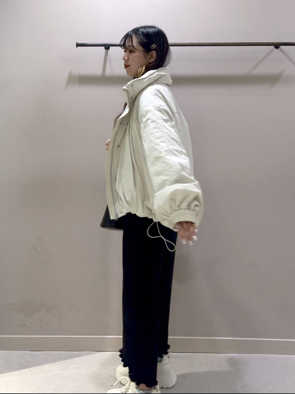 レッド系のニット/セーター、ホワイト系のその他アウター、ブラック系のスカートを着用したレディースの冬コーディネートの2枚目の写真