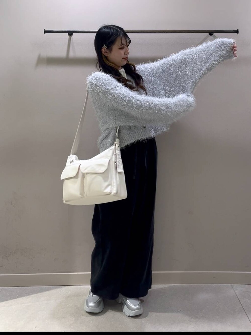 ホワイト系のショルダーバッグ、ホワイト系のTシャツ/カットソー、シルバー系のスニーカーを着用したレディースの冬コーディネートの5枚目の写真