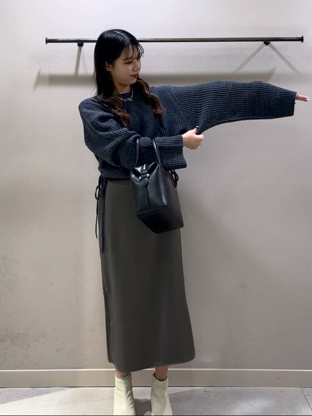 ブルー系のワンピース、ブラック系のショルダーバッグ、ホワイト系のブーツを着用したレディースの冬コーディネートの4枚目の写真