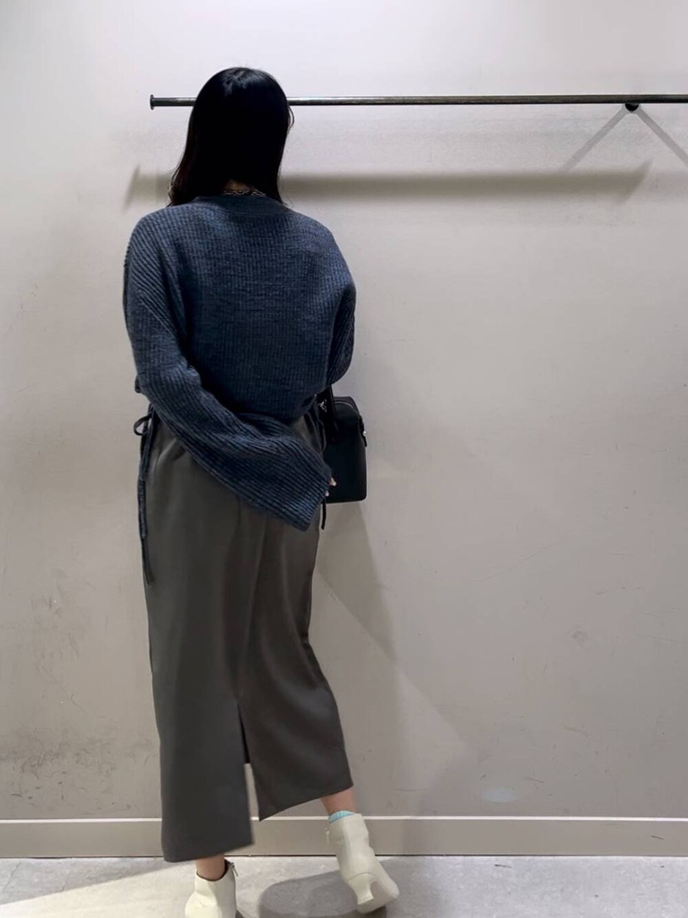 ブルー系のワンピース、ブラック系のショルダーバッグ、ホワイト系のブーツを着用したレディースの冬コーディネートの2枚目の写真