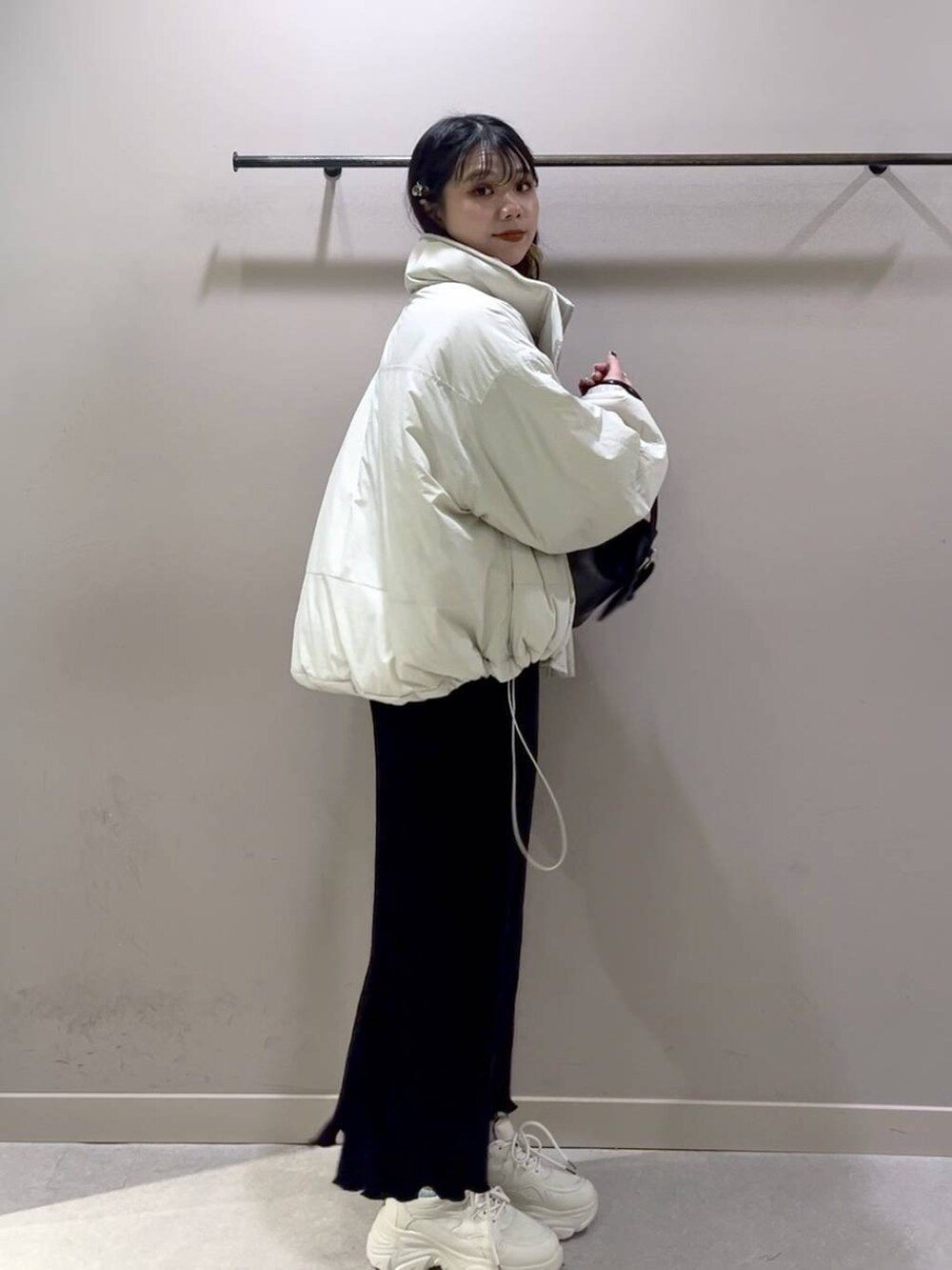 レッド系のニット/セーター、ホワイト系のその他アウター、ブラック系のスカートを着用したレディースの冬コーディネートの8枚目の写真