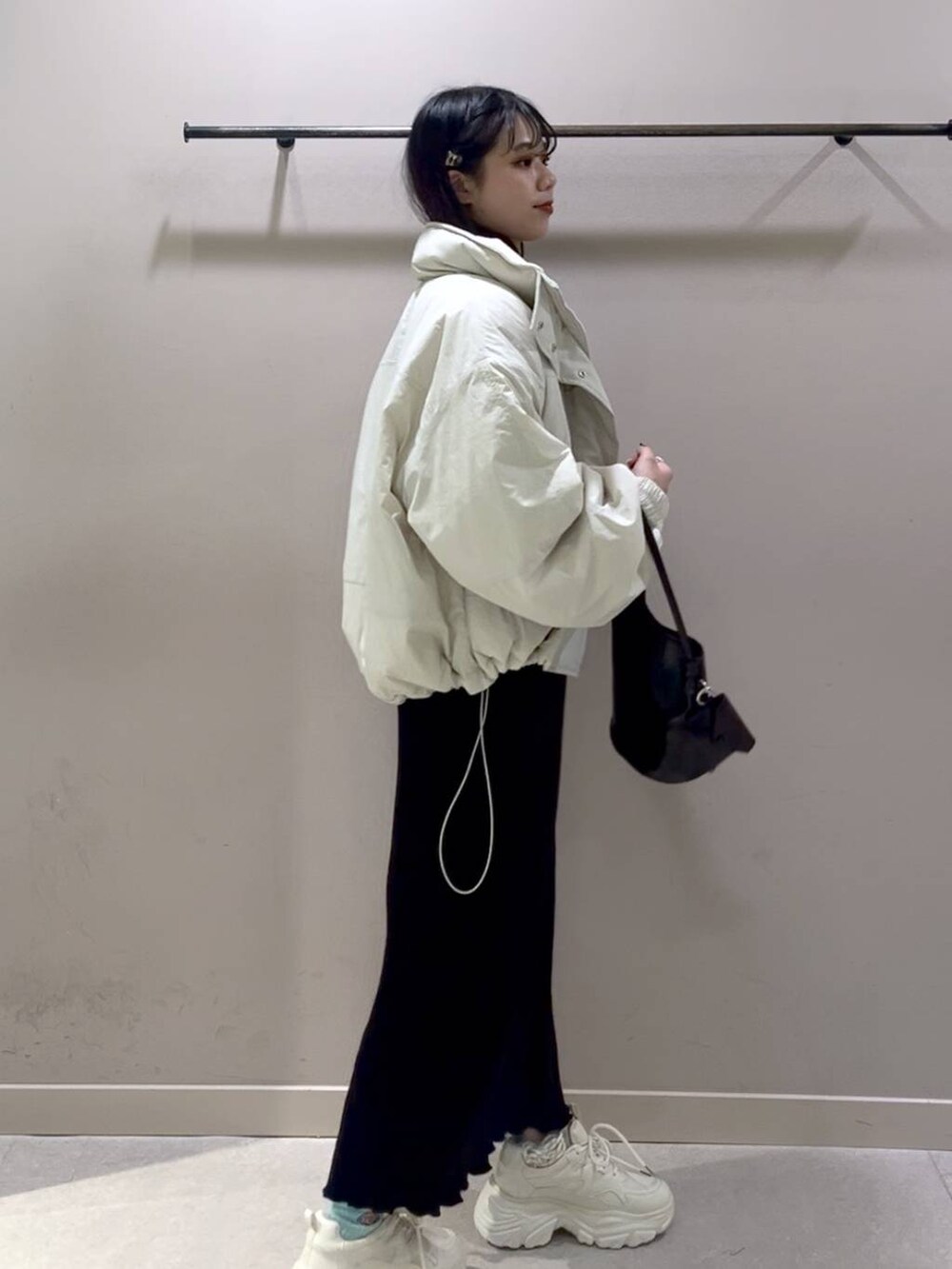 レッド系のニット/セーター、ホワイト系のその他アウター、ブラック系のスカートを着用したレディースの冬コーディネートの6枚目の写真