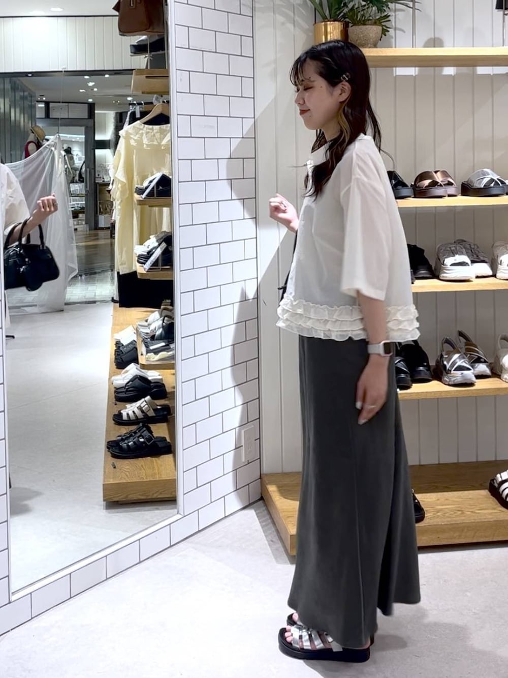 ベージュ系のTシャツ/カットソー、グレー系のスカート、シルバー系のサンダルを着用したレディースの夏コーディネートの2枚目の写真