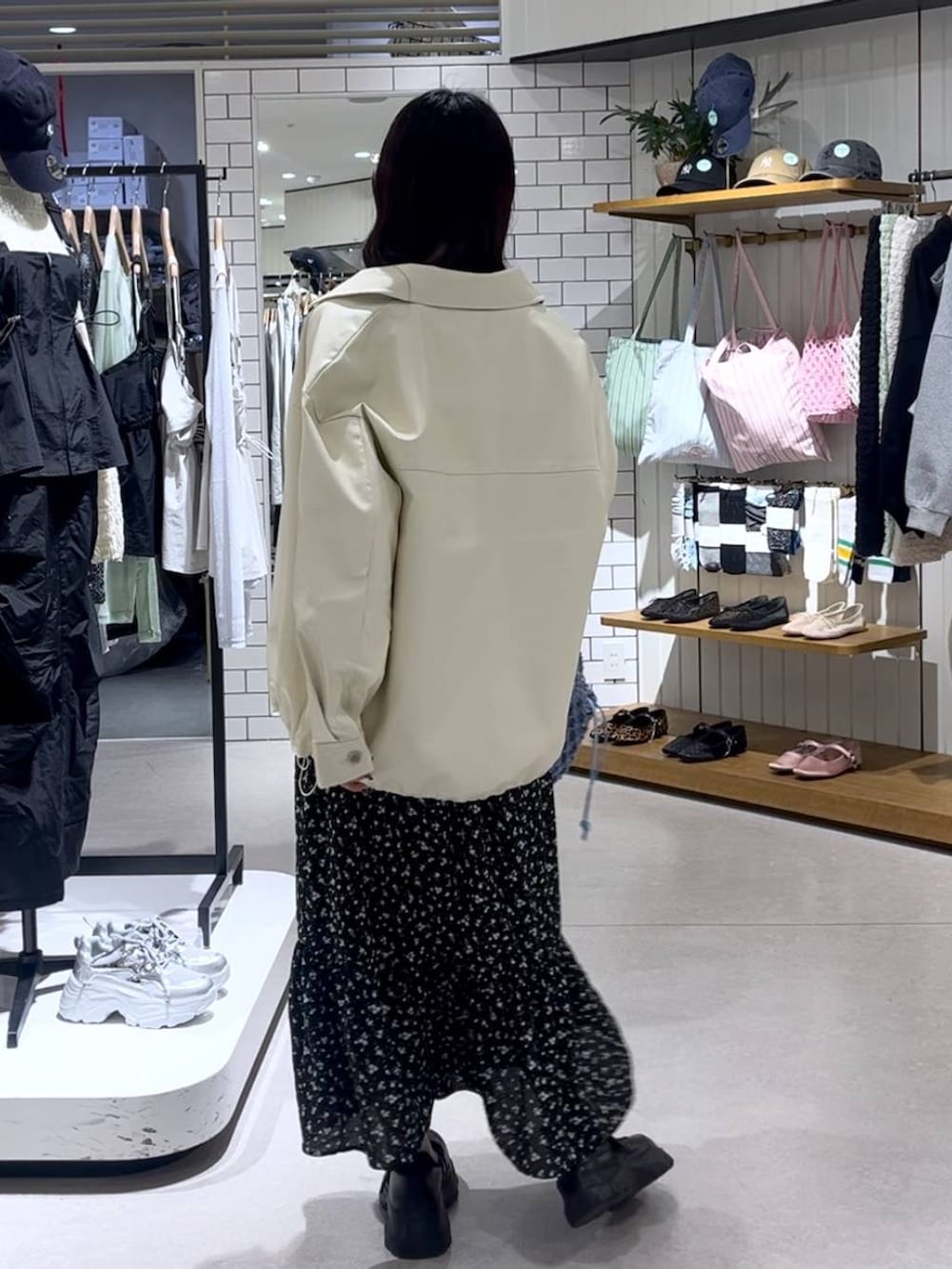 ブラック系のスニーカー、ブルー系のトートバッグ、ホワイト系のブルゾンを着用したレディースの春コーディネートの3枚目の写真