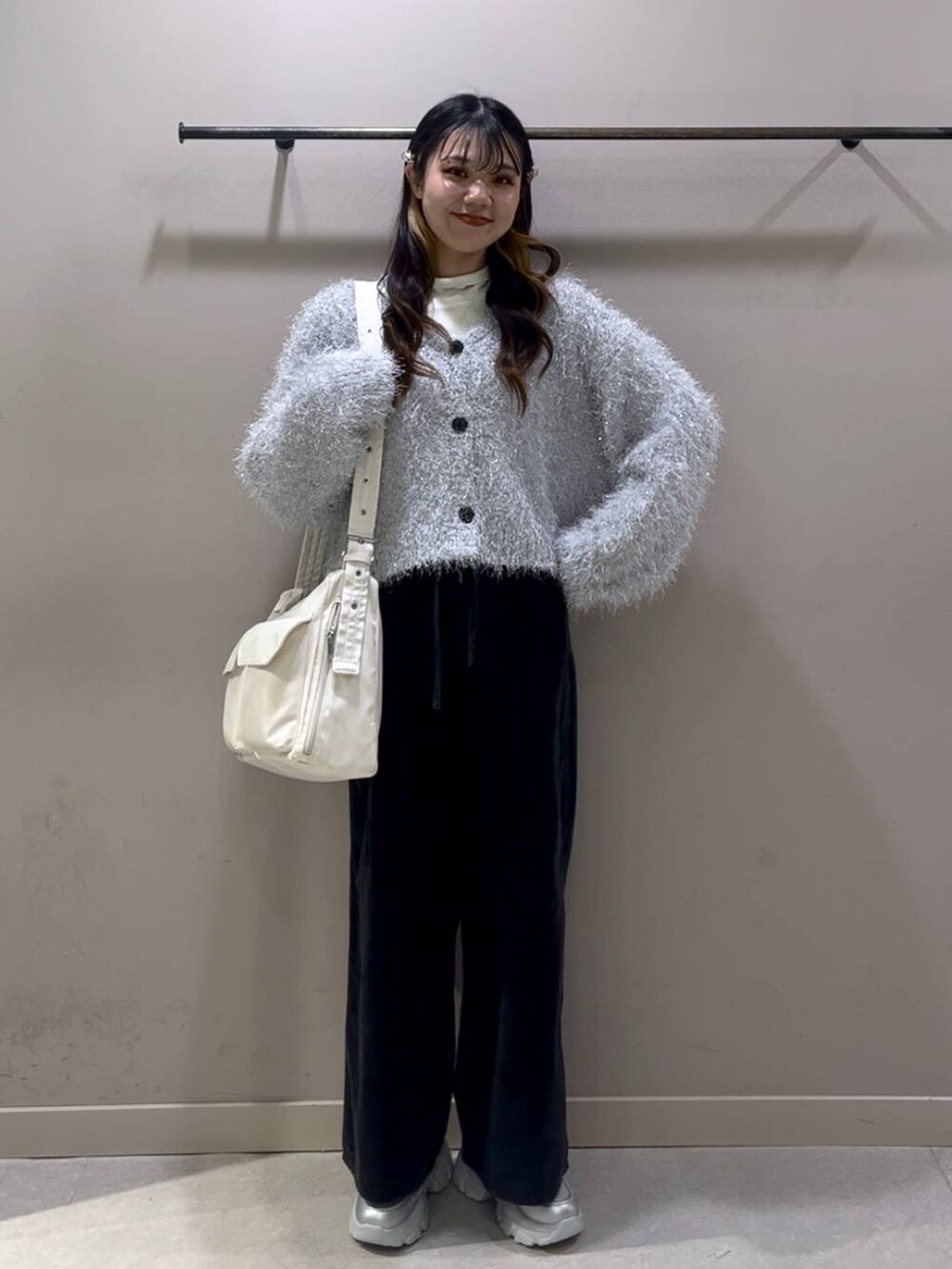 ホワイト系のショルダーバッグ、ホワイト系のTシャツ/カットソー、シルバー系のスニーカーを着用したレディースの冬コーディネートの7枚目の写真