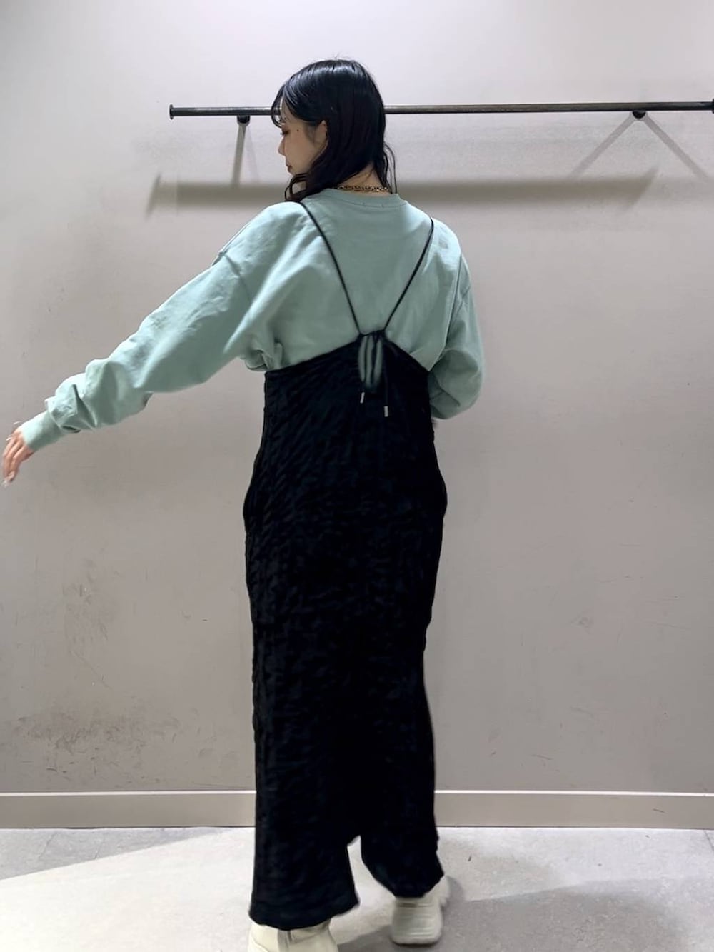 ホワイト系のブーツ、グリーン系のスウェット、ブラック系のワンピースを着用したレディースの冬コーディネートの2枚目の写真