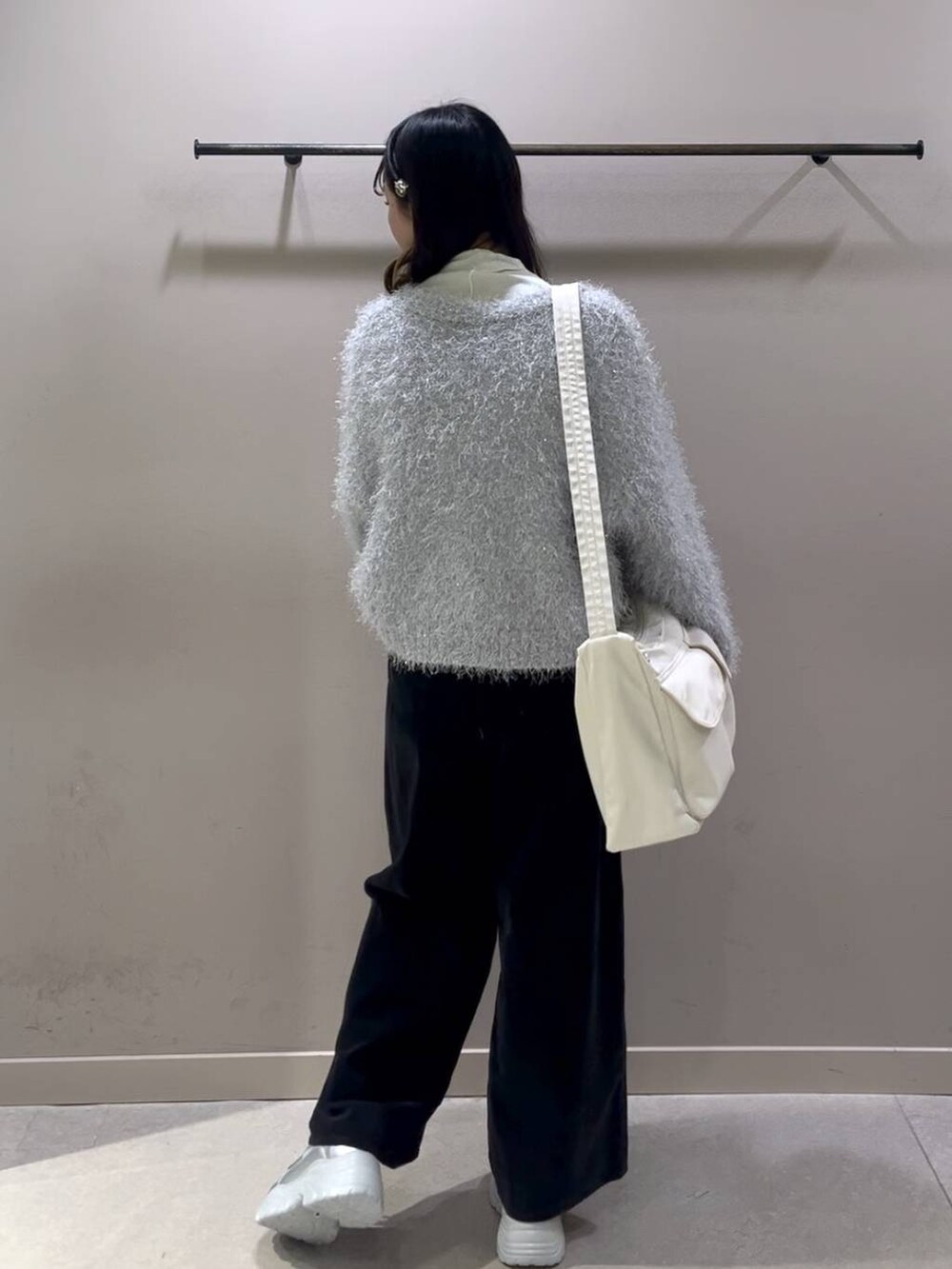 ホワイト系のショルダーバッグ、ホワイト系のTシャツ/カットソー、シルバー系のスニーカーを着用したレディースの冬コーディネートの3枚目の写真