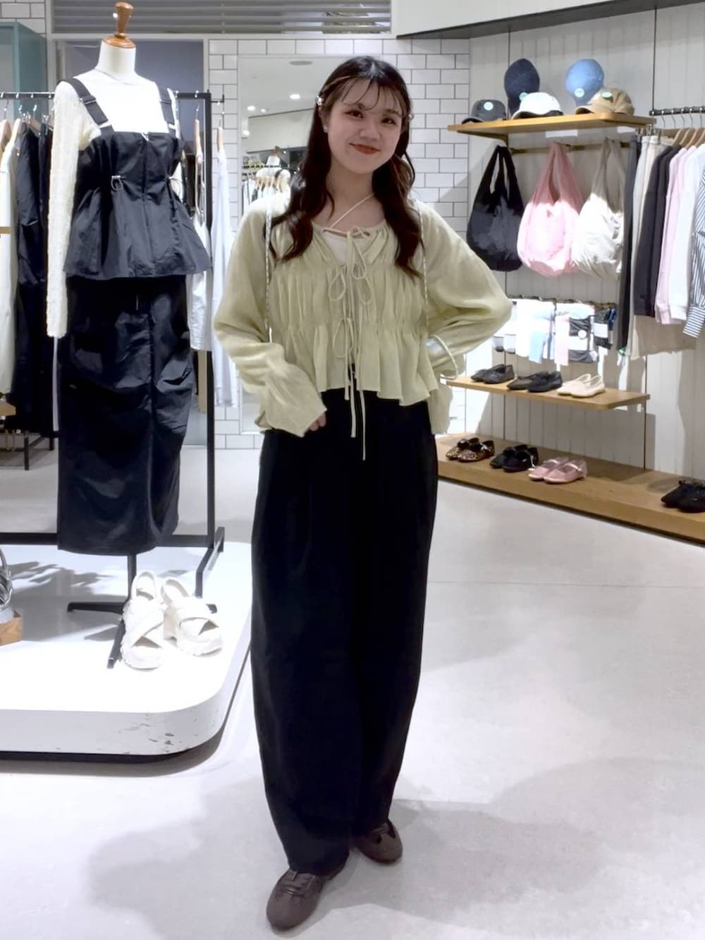 ブラウン系のスニーカー、ベージュ系のキャミソール、ホワイト系のバックパック/リュックを着用したレディースの春コーディネートの5枚目の写真