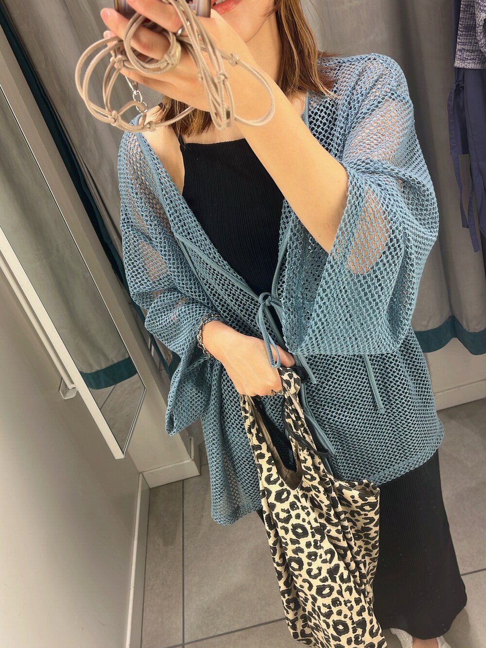 ブラック系のスカート、ブルー系のカーディガン/ボレロ、ブラック系のキャミソールを着用したレディースの夏コーディネートの2枚目の写真