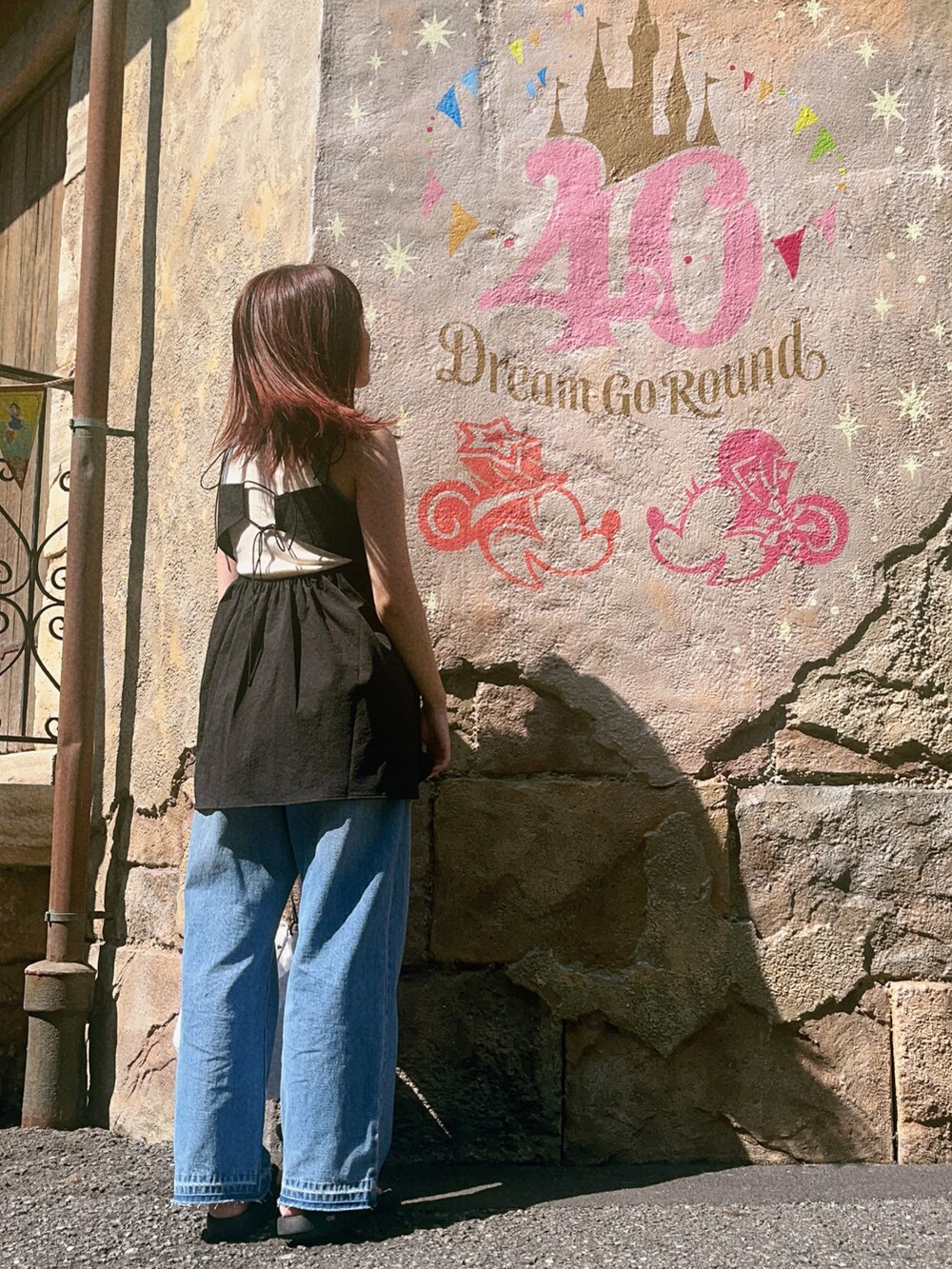 ブルー系のデニムパンツ、ブラック系のキャミソール、ホワイト系のタンクトップを着用したレディースの夏コーディネートの2枚目の写真