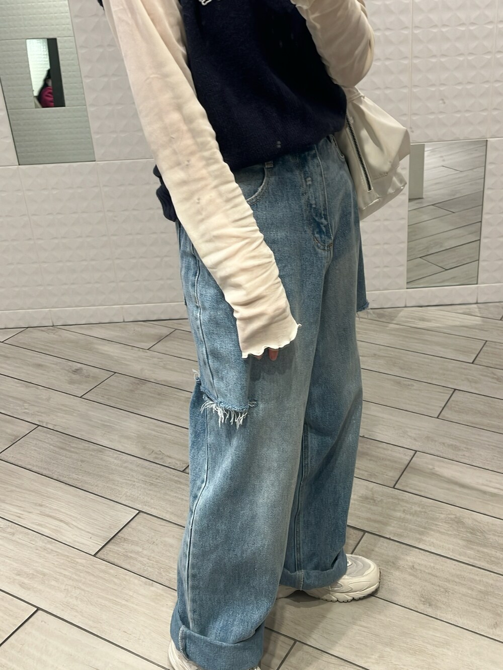 ブルー系のベスト、ホワイト系のTシャツ/カットソー、ブルー系のデニムパンツを着用したレディースの冬コーディネートの3枚目の写真