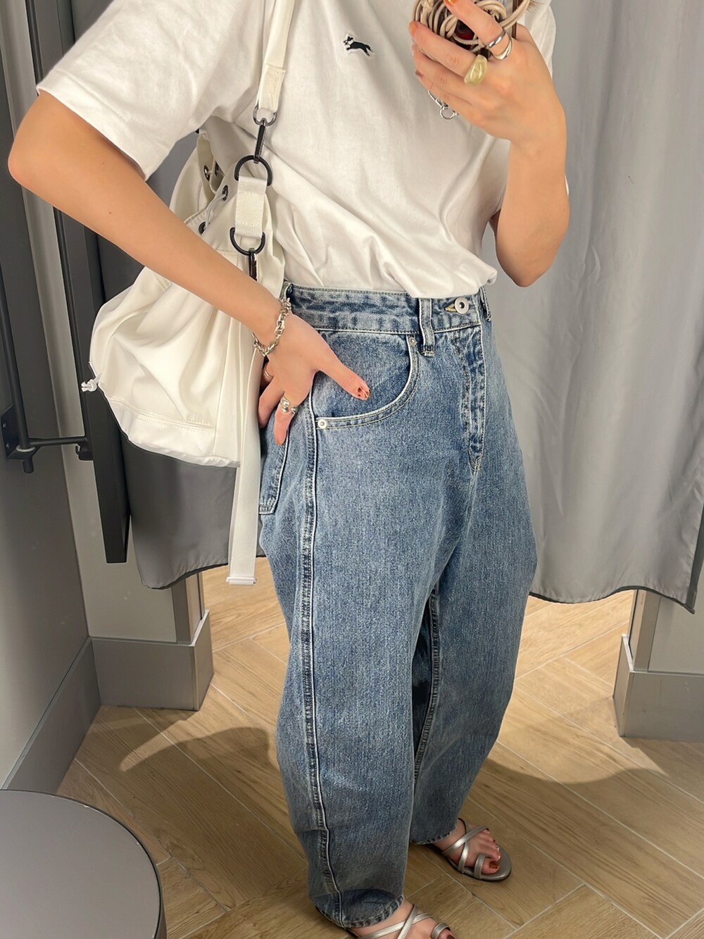 ブルー系のデニムパンツ、ホワイト系のショルダーバッグ、ホワイト系のTシャツ/カットソーを着用したレディースの夏コーディネートの2枚目の写真