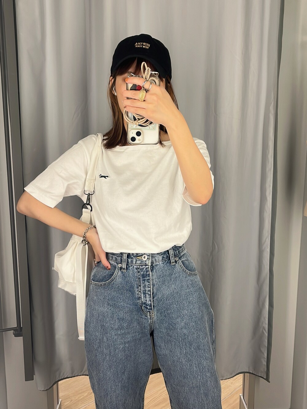 ブルー系のデニムパンツ、ホワイト系のショルダーバッグ、ホワイト系のTシャツ/カットソーを着用したレディースの夏コーディネートの3枚目の写真