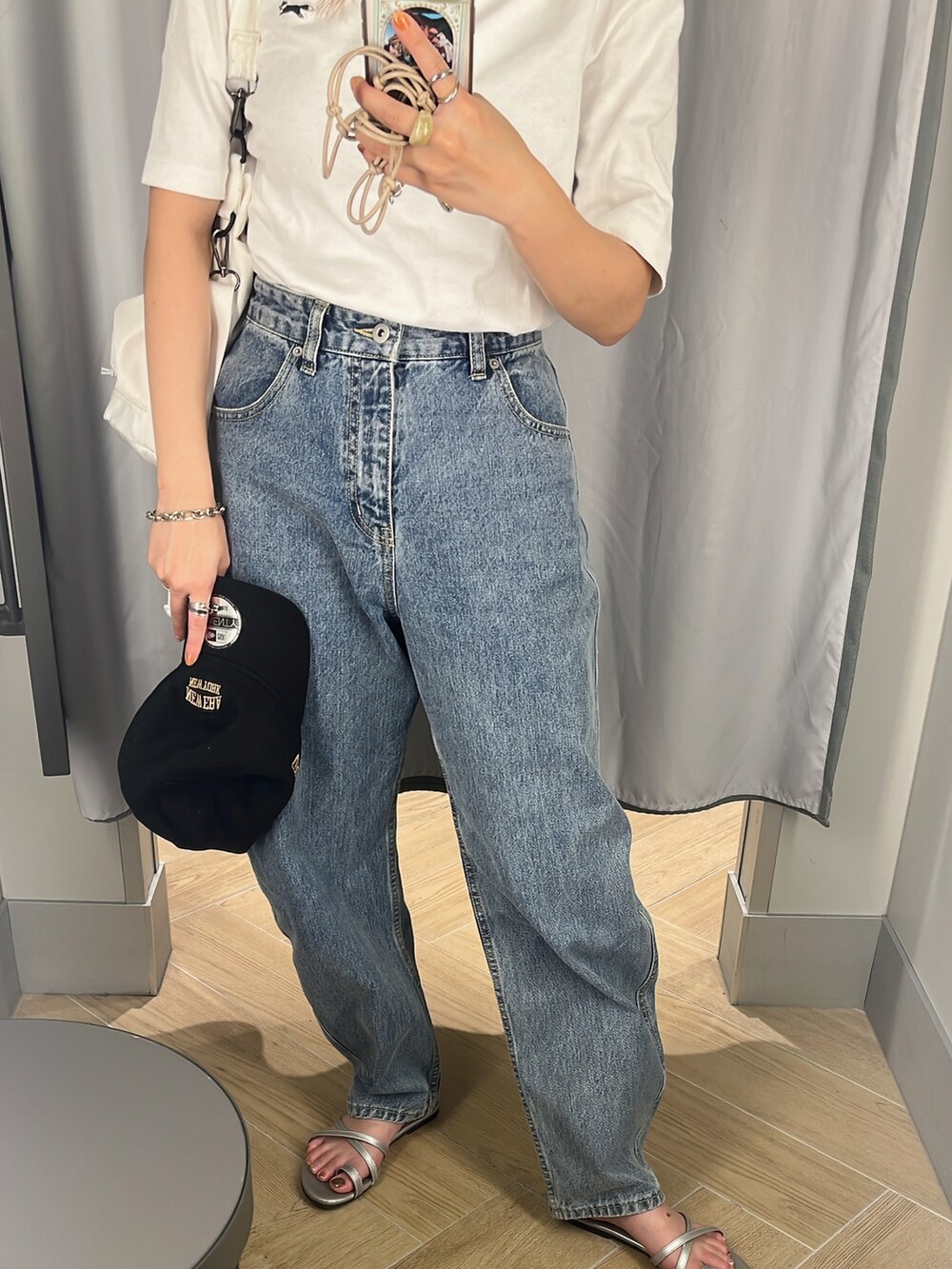 ブルー系のデニムパンツ、ホワイト系のショルダーバッグ、ホワイト系のTシャツ/カットソーを着用したレディースの夏コーディネートの4枚目の写真