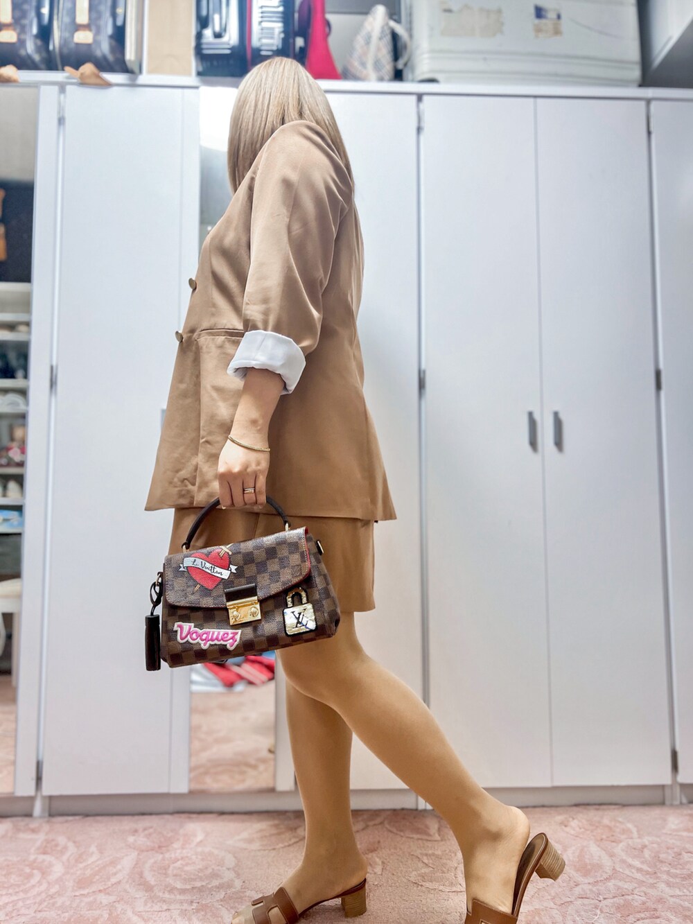 ブラウン系のハンドバッグ、ブラウン系のサンダルを着用したレディースの秋コーディネートの2枚目の写真