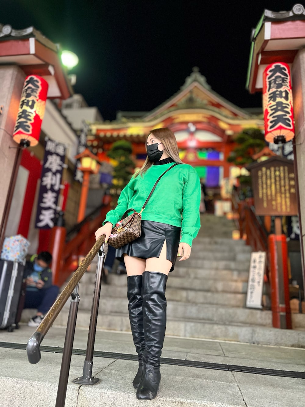 ブラック系のスカート、グリーン系のスウェット、ブラウン系のショルダーバッグを着用したレディースの秋コーディネートの2枚目の写真