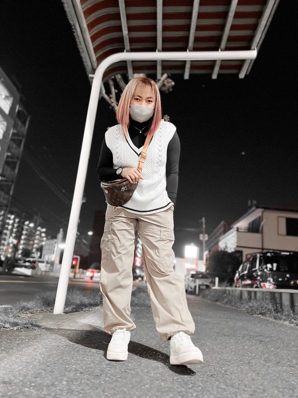 ベージュ系のカーゴパンツ、ホワイト系のスニーカー、ブラウン系のボディバッグ/ウエストポーチを着用したレディースの秋コーディネートの2枚目の写真