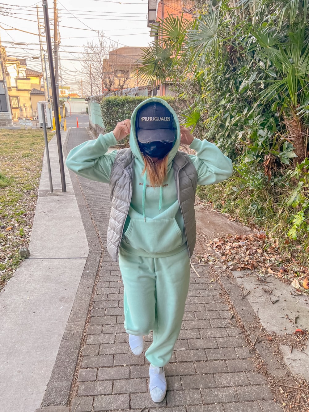 グレー系のスーツベスト、ホワイト系のスニーカーを着用したレディースの秋コーディネートの2枚目の写真