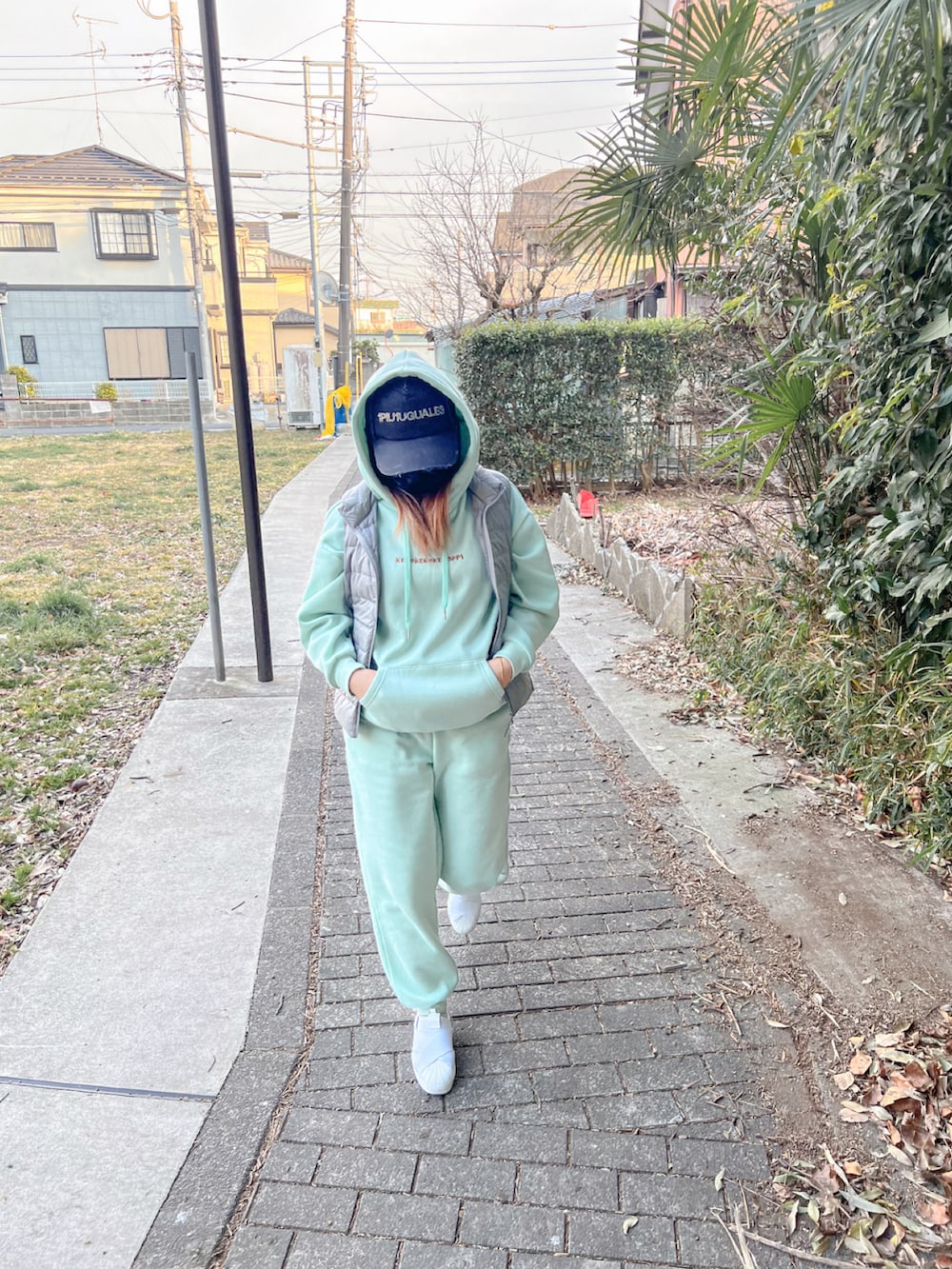 グレー系のスーツベスト、ホワイト系のスニーカーを着用したレディースの秋コーディネートの3枚目の写真