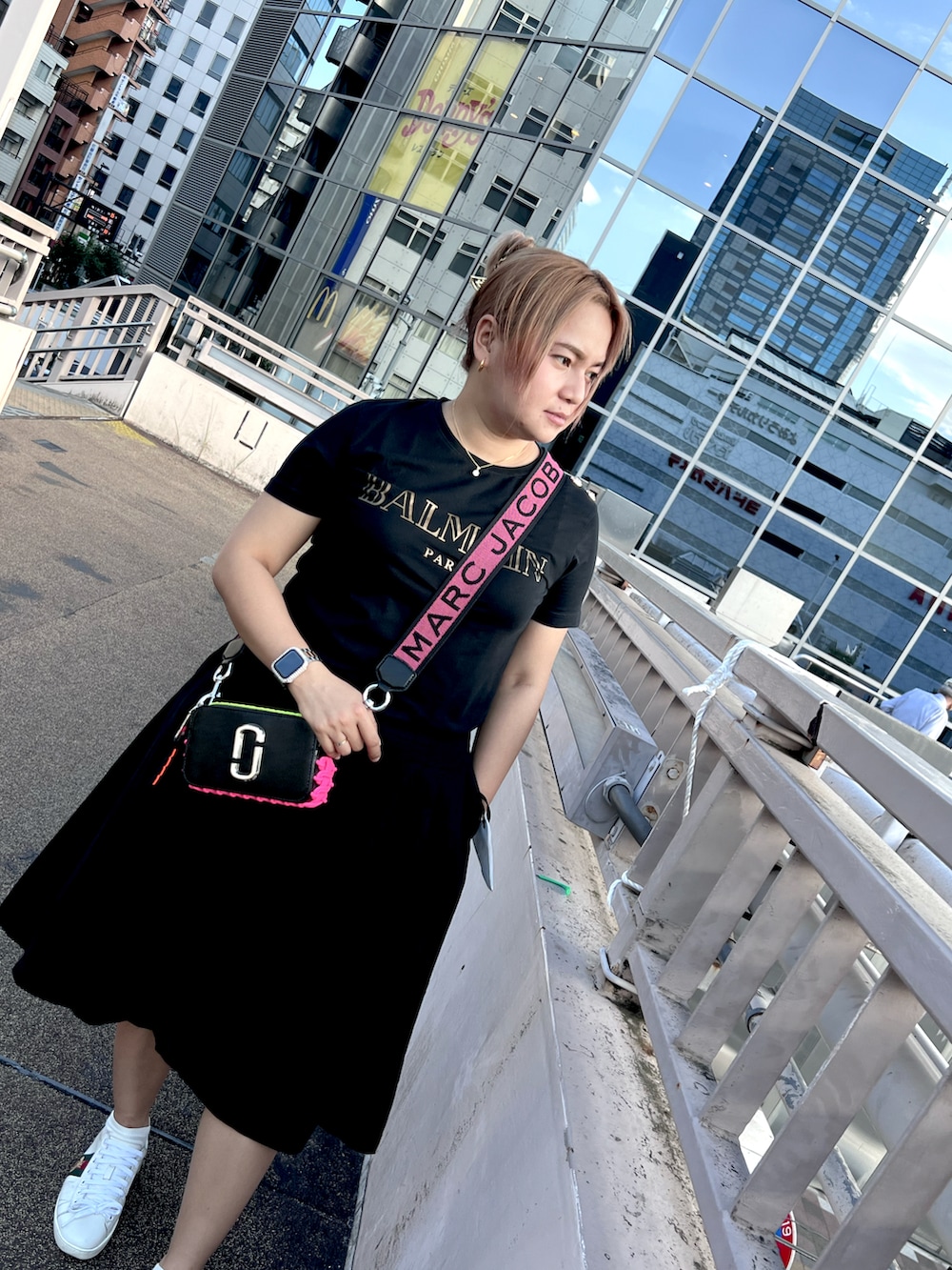 ブラック系のショルダーバッグ、ホワイト系のスニーカー、ブラック系のTシャツ/カットソーを着用したレディースの夏コーディネートの3枚目の写真