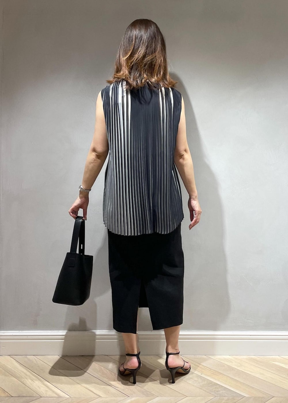 ブラック系のスカート、ブラック系のシャツ/ブラウス、ブラック系のハンドバッグを着用したレディースの春コーディネートの4枚目の写真