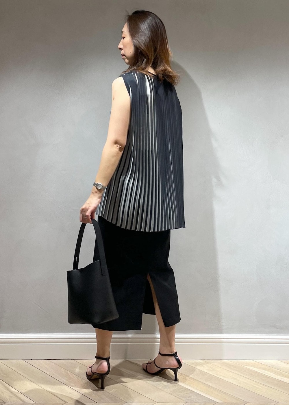 ブラック系のスカート、ブラック系のシャツ/ブラウス、ブラック系のハンドバッグを着用したレディースの春コーディネートの3枚目の写真