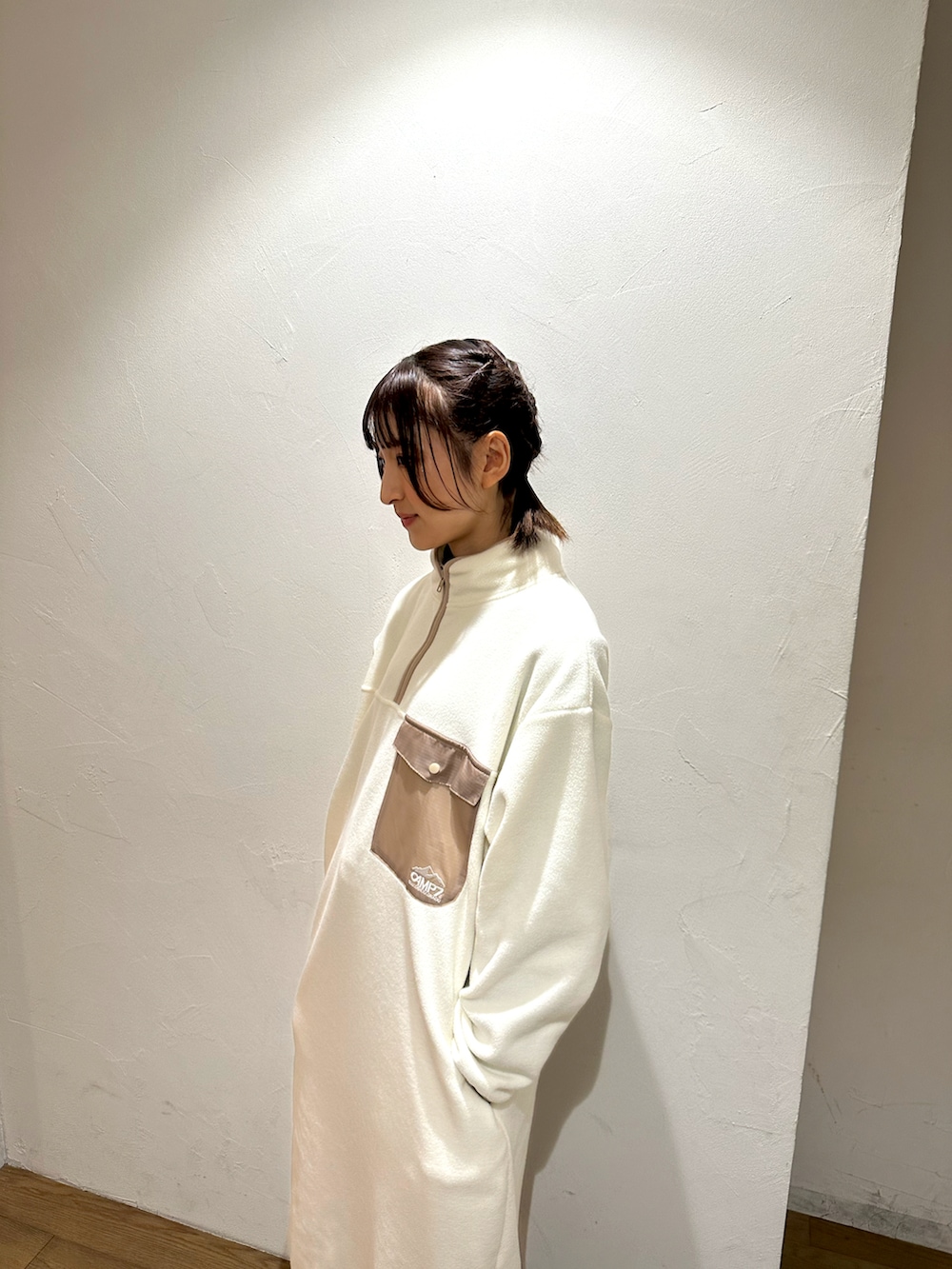 ホワイト系のワンピース、ブラウン系のスラックス、ベージュ系のスニーカーを着用したレディースの冬コーディネートの2枚目の写真