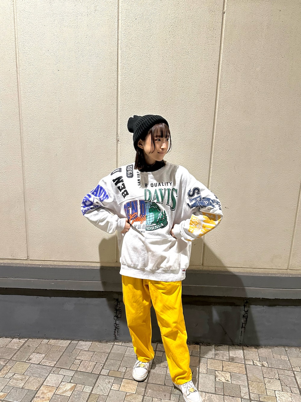 イエロー系のチノパンツ、ホワイト系のスニーカー、ホワイト系のスウェットを着用したレディースの秋コーディネートの2枚目の写真