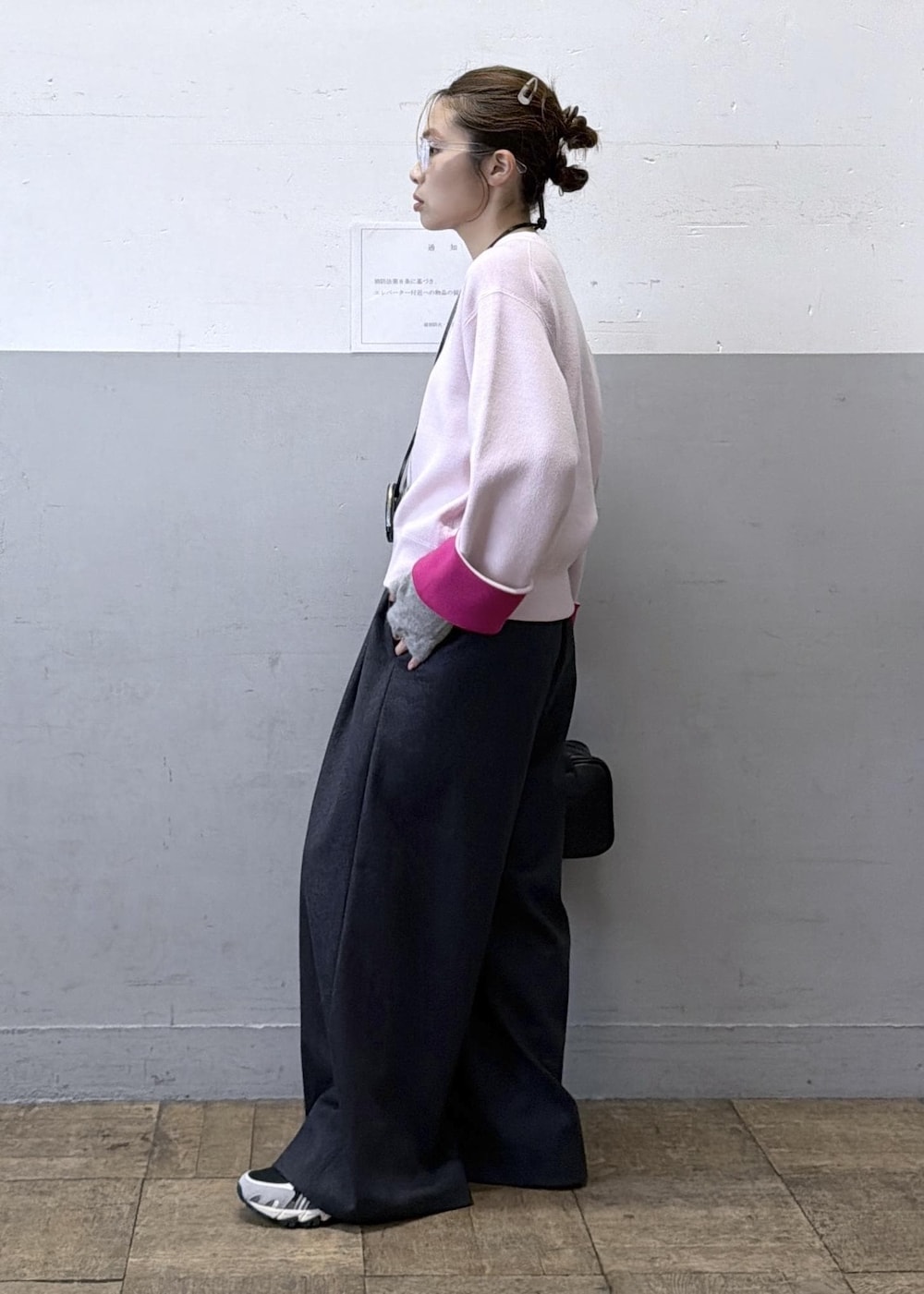 ブラック系のショルダーバッグ、グレー系のスラックス、ピンク系のニット/セーターを着用したレディースの秋コーディネートの2枚目の写真