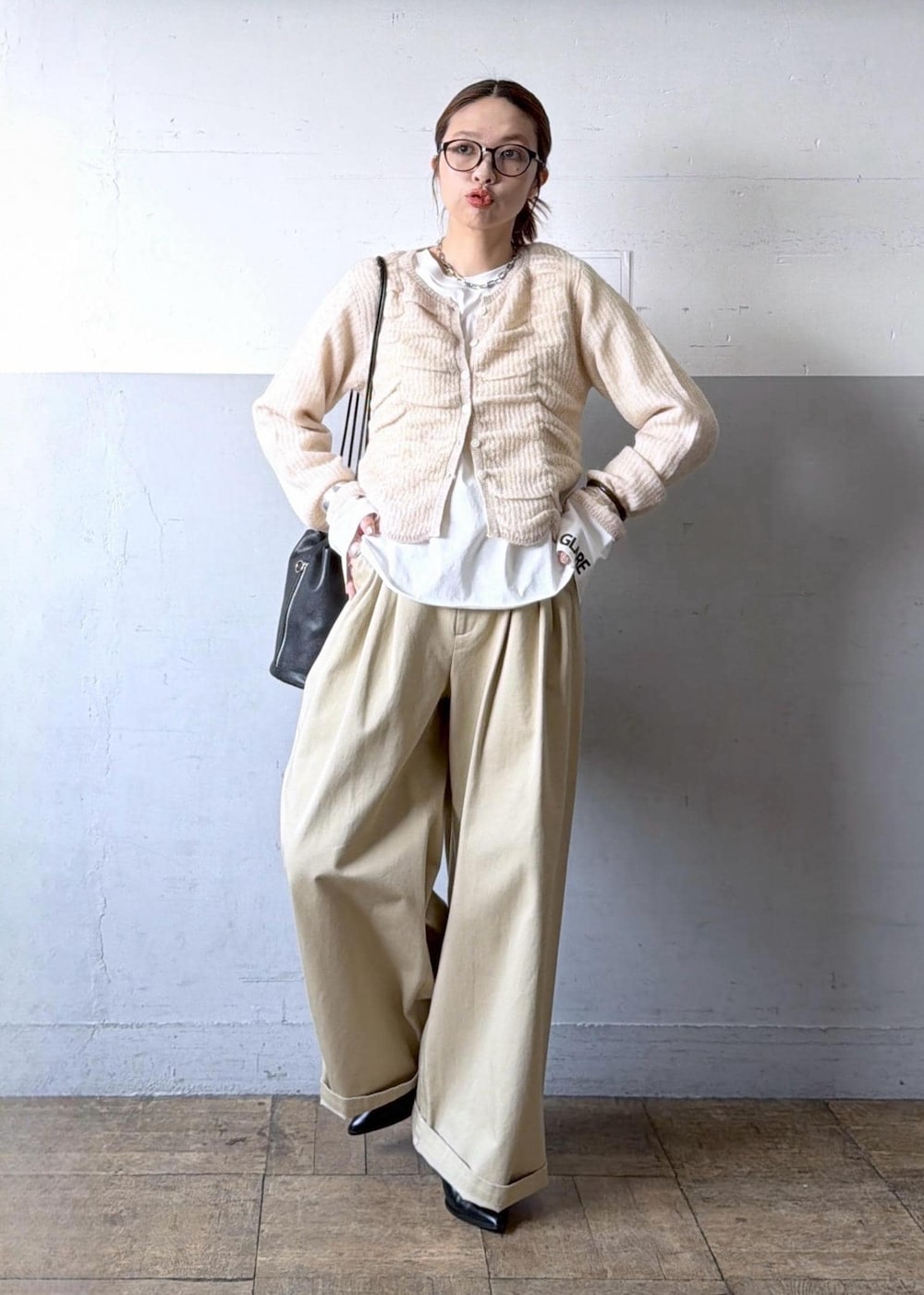 ベージュ系のカーディガン/ボレロ、ブラック系のブーツ、ホワイト系のTシャツ/カットソーを着用したレディースの冬コーディネートの2枚目の写真