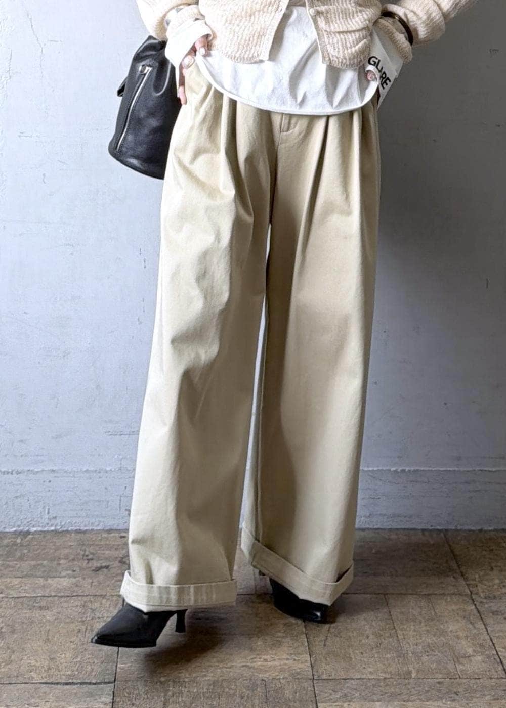 ベージュ系のカーディガン/ボレロ、ブラック系のブーツ、ホワイト系のTシャツ/カットソーを着用したレディースの冬コーディネートの9枚目の写真