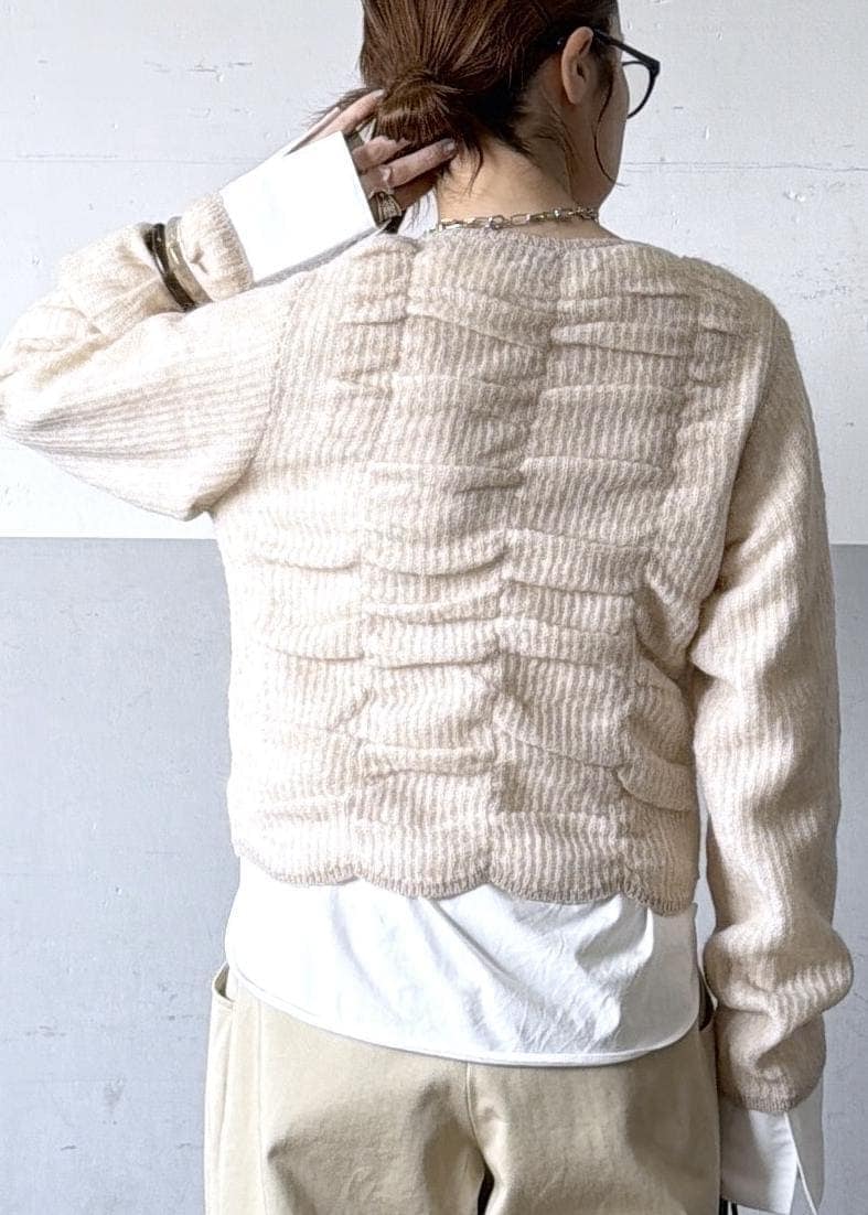 ベージュ系のカーディガン/ボレロ、ブラック系のブーツ、ホワイト系のTシャツ/カットソーを着用したレディースの冬コーディネートの8枚目の写真