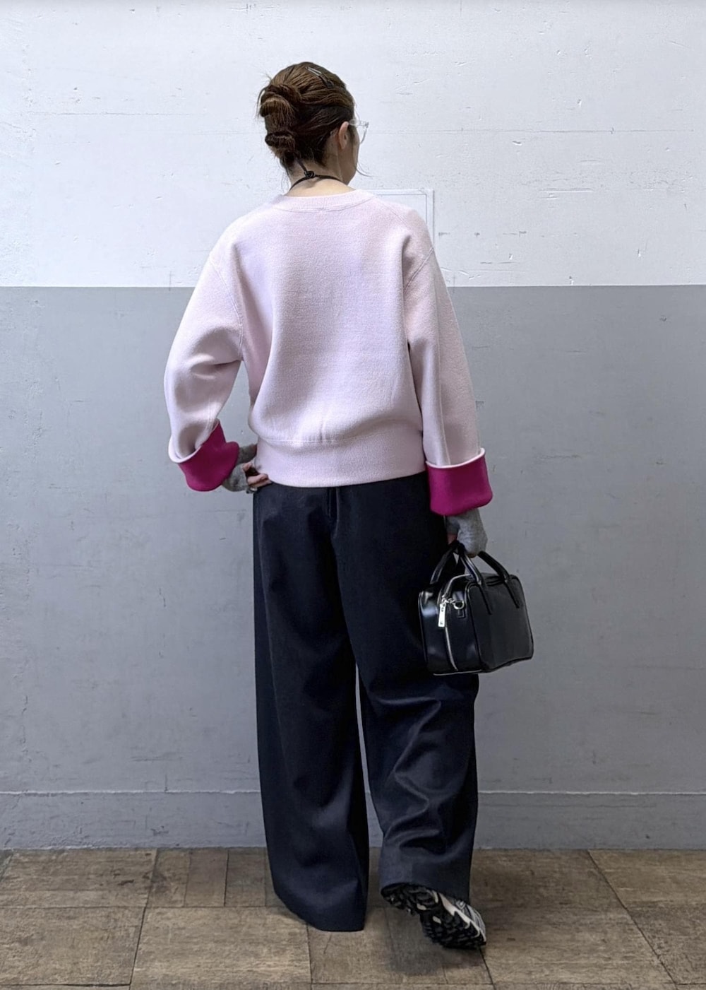 ブラック系のショルダーバッグ、グレー系のスラックス、ピンク系のニット/セーターを着用したレディースの秋コーディネートの3枚目の写真