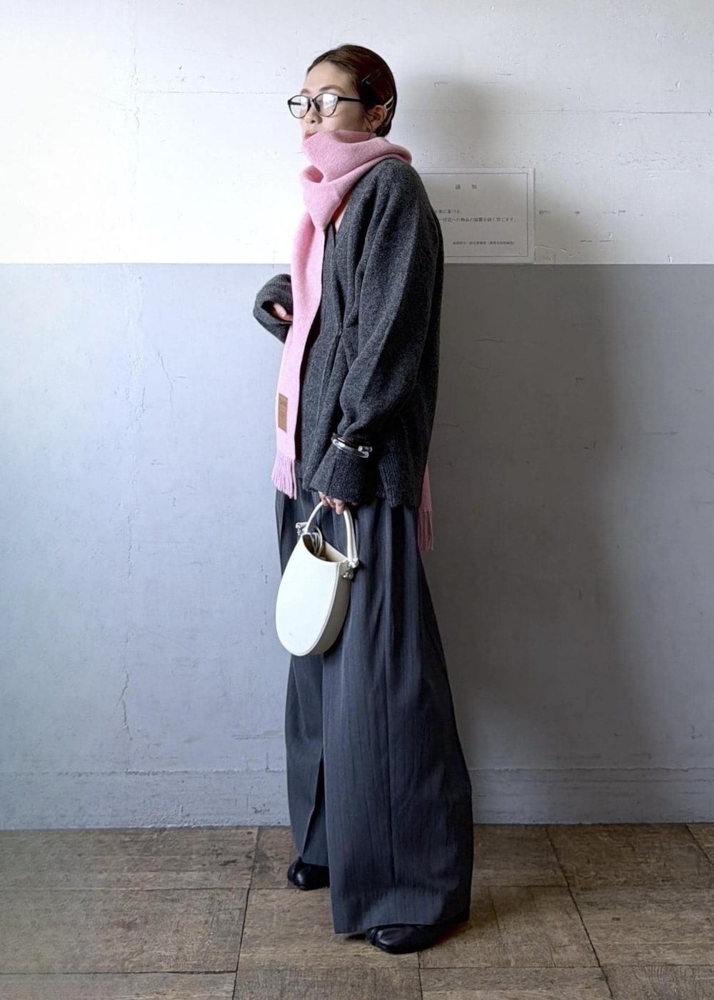 ホワイト系のハンドバッグ、グレー系のスラックス、グレー系のニット/セーターを着用したレディースの秋コーディネートの3枚目の写真