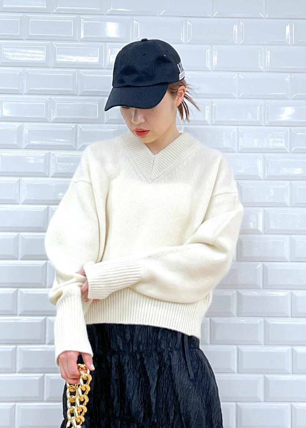 ブラック系のブーツ、ブラック系のスカート、ホワイト系のニット/セーターを着用したレディースの夏コーディネートの5枚目の写真