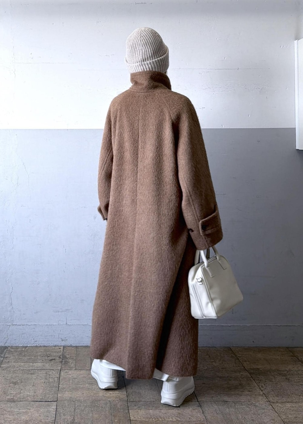 ベージュ系のスニーカー、イエロー系のステンカラーコート、ホワイト系のワンピースを着用したレディースの冬コーディネートの4枚目の写真