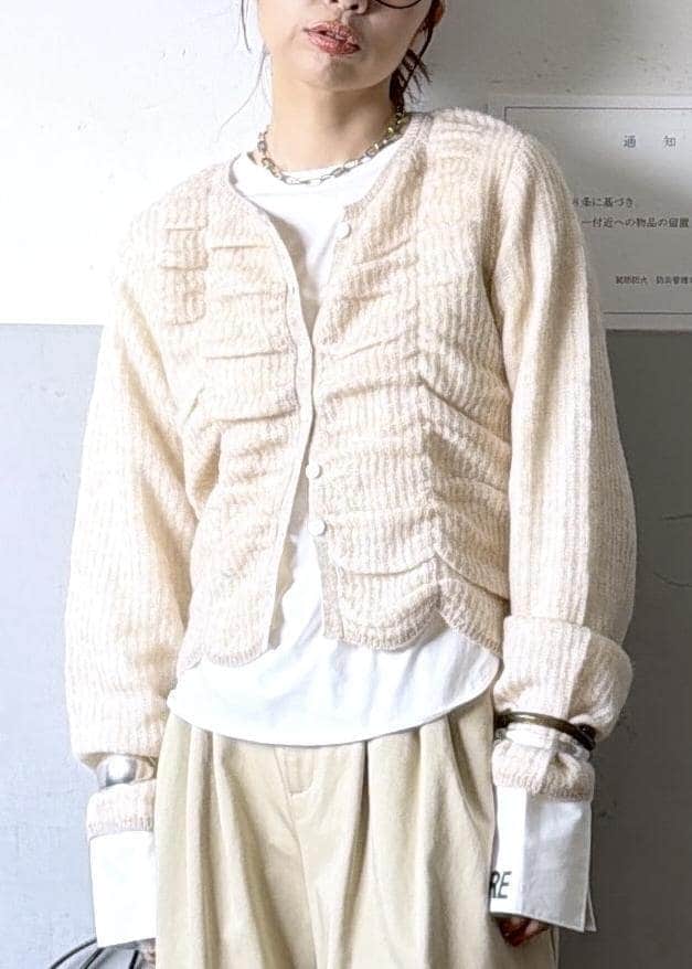 ベージュ系のカーディガン/ボレロ、ブラック系のブーツ、ホワイト系のTシャツ/カットソーを着用したレディースの冬コーディネートの6枚目の写真